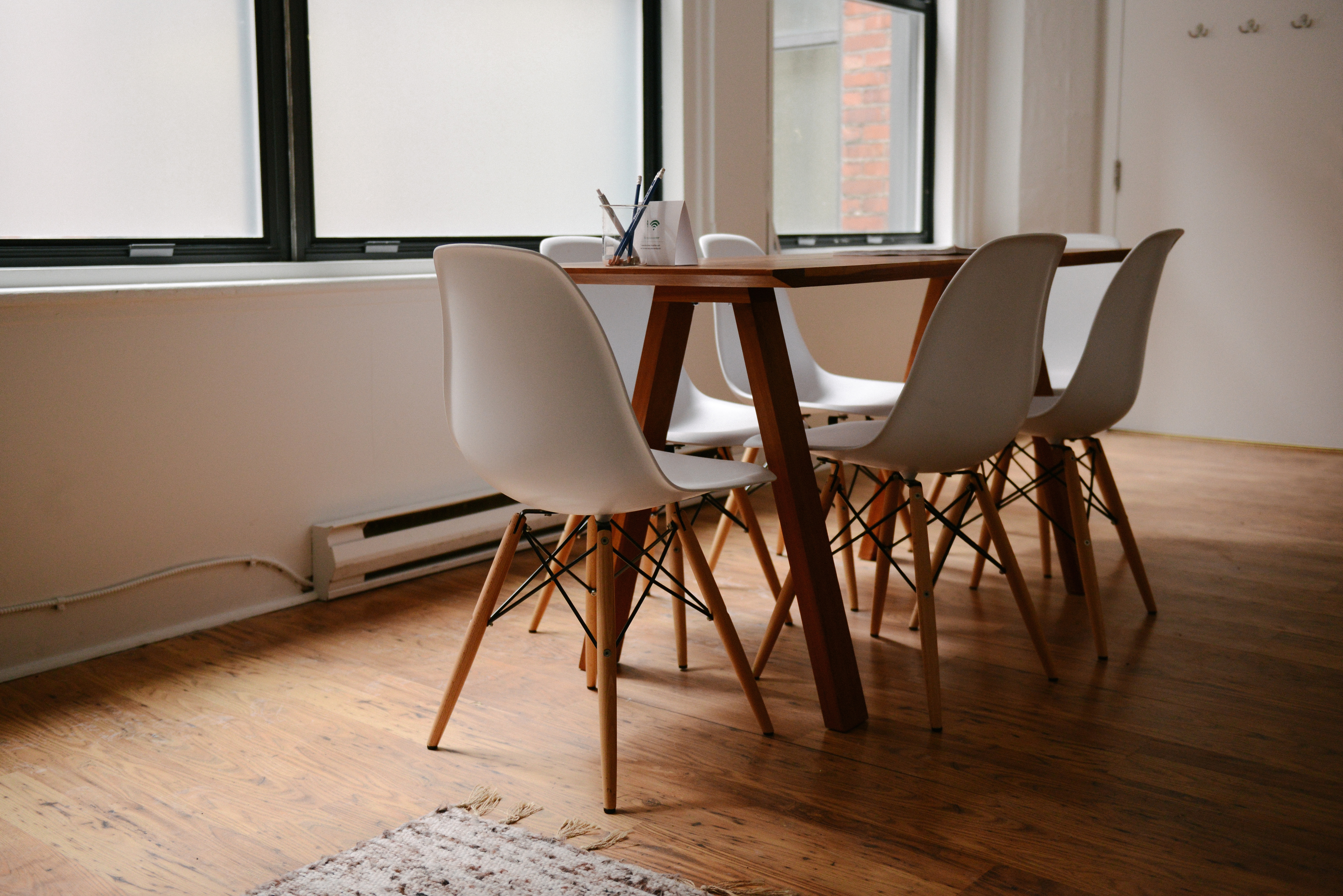 work table with white chairs and reclaimed wood floors